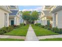 Inviting walkway between well-maintained townhouses with lush landscaping at 200 Southern Pecan Cir # 105, Winter Garden, FL 34787