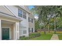 Two-story townhouse with green door and manicured lawn at 200 Southern Pecan Cir # 105, Winter Garden, FL 34787