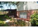 Back exterior with brick patio, wooden deck, and lush landscaping at 1879 Lake Emma Rd, Longwood, FL 32750