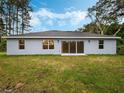 Rear view of house showcasing sliding glass doors leading to a backyard at 31355 Nutmeg Ave, Eustis, FL 32736