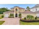 Two-story house with a tan facade, brown roof, and a three-car garage at 1160 Grand Traverse Pkwy, Reunion, FL 34747