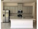 Modern kitchen with an island, stainless steel appliances and light gray cabinets at 2331 Datura Loop, St Cloud, FL 34772
