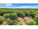 Aerial view of a house on a wooded lot with a shed at 5136 Mcdonald Rd, Zellwood, FL 32798
