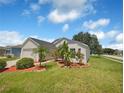 Exterior view showcasing a two-car garage and lush landscaping with palm trees at 205 Hibiscus St, Winter Haven, FL 33881