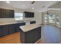 Eat-in kitchen with dark cabinetry, an island, and plenty of natural light at 205 Hibiscus St, Winter Haven, FL 33881