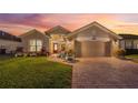 House exterior at dusk showcasing landscaping and driveway at 442 Ella Mae Dr, Davenport, FL 33897