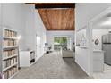 Bright living room with vaulted ceilings and wood beams, carpeted floors, and access to balcony at 200 Maitland Ave # 20, Altamonte Springs, FL 32701