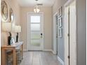 Bright entryway with console table, mirrors, and tiled floor at 8834 Cabot Cliffs Dr, Davenport, FL 33896