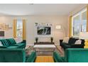 Living room with green velvet sofas, large TV, and yellow accents at 8834 Cabot Cliffs Dr, Davenport, FL 33896