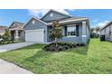 Newly constructed home with gray exterior, white garage door, and landscaping at 530 Ellie Ct, Apopka, FL 32703