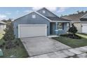 Newly built home with a gray exterior, white garage door, and a neatly landscaped yard at 530 Ellie Ct, Apopka, FL 32703