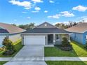 Gray house with white garage door and landscaping at 524 Ellie Ct, Apopka, FL 32703