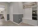Bright entryway with built-in bench, storage, and gray-and-white decor at 4270 Lana Ave, Davenport, FL 33897
