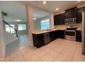 Modern kitchen with dark cabinetry, stainless steel appliances, and granite countertops at 14154 Dove Hollow Dr, Orlando, FL 32824