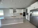 Modern kitchen with white cabinets, stainless steel appliances, and an island at 128 Lake Dr, Oviedo, FL 32765