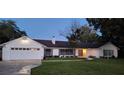 White two-car garage home with mature landscaping at 1030 Gregory Dr, Maitland, FL 32751
