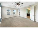 Spacious main bedroom with carpet, ceiling fan, and en-suite bathroom at 7574 Marker Ave, Kissimmee, FL 34747