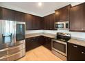 Modern kitchen with stainless steel appliances and dark brown cabinets at 7574 Marker Ave, Kissimmee, FL 34747