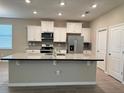 Modern kitchen with white cabinets, granite counters, and stainless steel appliances at 17926 Hither Hills Cir, Winter Garden, FL 34787