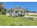 Charming light gray house with dark trim and landscaping at 702 S Myrtle Ave, New Smyrna Beach, FL 32168