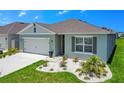 Curb appeal with gray exterior, white garage door, and well maintained landscaping at 1157 Torrente Ln, Haines City, FL 33844