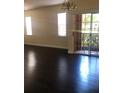 Bright living room featuring dark hardwood floors and sliding door access to a balcony at 1325 Rotonda Pt # 125, Lake Mary, FL 32746