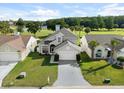 Two-story house with gray siding, white garage door, and manicured lawn, near golf course at 2715 Autumn Green Dr, Orlando, FL 32822