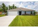 Newly built home with a two-car garage and a well-maintained lawn at 15031 Sw 28Th Terrace Rd, Ocala, FL 34473