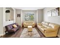 Spacious living room featuring light leather sofas and dark wood floors at 2524 Dover Glen Cir, Orlando, FL 32828