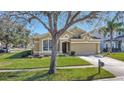 Attractive tan house with a well-manicured lawn and driveway at 2524 Dover Glen Cir, Orlando, FL 32828