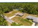 Aerial view of a house with a large yard and surrounding trees at 33 Fisher Run Ter, Ocklawaha, FL 32179