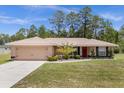 One-story home with a two-car garage and landscaped yard at 33 Fisher Run Ter, Ocklawaha, FL 32179