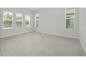 Bright bedroom with wood-look floors and multiple windows at 3860 Rose Malllow Dr, Kissimmee, FL 34746