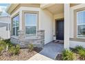 Front entry with stone accents, dark door, and brick walkway at 13479 Panama Beach Ct, Orlando, FL 32827