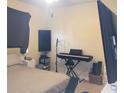 Bright bedroom with a bed, musical keyboard, and large TV at 6682 Time Square Ave # 101, Orlando, FL 32835
