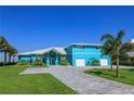 Beautiful teal home with a large driveway and two-car garage at 1112 N Peninsula Ave, New Smyrna Beach, FL 32169