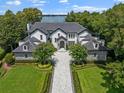 Elegant two-story home with a paved driveway and lush landscaping at 9832 Laurel Valley Dr, Windermere, FL 34786