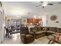 Open living room and kitchen with brown reclining sofa and dining set at 31 Diamond Ridge Way, Ocala, FL 34472
