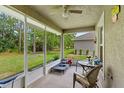 Relaxing screened porch with outdoor furniture and ceiling fan at 31 Diamond Ridge Way, Ocala, FL 34472