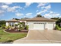 House exterior with landscaping and two car garage at 12857 Se 92Nd Court Rd, Summerfield, FL 34491