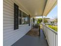 Front porch with a wooden deck and white railing at 17775 Se 101St Ct, Summerfield, FL 34491