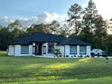 One story home with white exterior, black accents and landscaping at 6210 Sw 133Rd Terrace Rd, Ocala, FL 34481