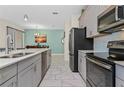 Modern kitchen with gray cabinets, white countertops, and stainless steel appliances at 8984 Stinger Dr, Champions Gate, FL 33896