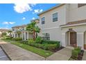 Exterior of a two-story townhome with landscaping and a walkway at 8984 Stinger Dr, Champions Gate, FL 33896