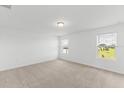 Spacious bedroom with carpeted floor and two windows at 1128 Griffon Ave, Lake Alfred, FL 33850