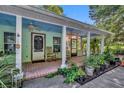 Inviting front porch with rocking chairs, brick flooring, and lush landscaping at 191 E Ponkan Rd, Apopka, FL 32712
