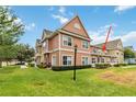 Two-story townhome with light peach siding and a grassy yard at 2211 San Vittorino Cir # 105, Kissimmee, FL 34741