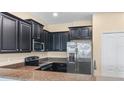 Modern kitchen with dark cabinetry, granite counters and stainless steel appliances at 8940 Azalea Sands Ln # 8940, Davenport, FL 33896
