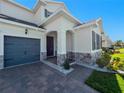House exterior showcasing stone accents and a gray garage door at 30053 Island Club Dr, Tavares, FL 32778