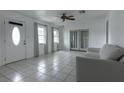 Living room with tiled floors, white walls, and a comfy sofa at 809 Florida Pkwy, Kissimmee, FL 34743